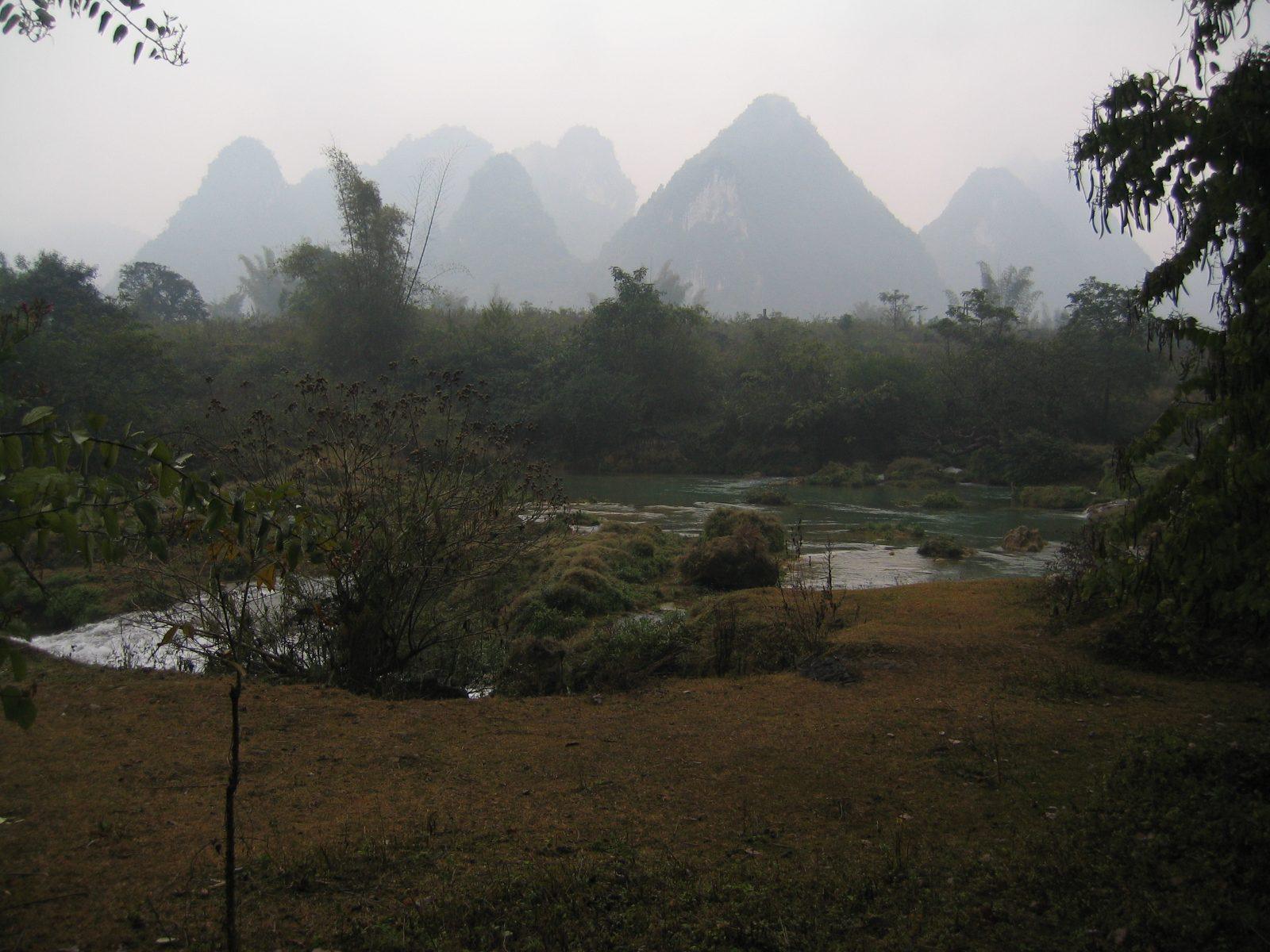 Ban Gioc Waterfall and the surrounding karst landscape in morning mist