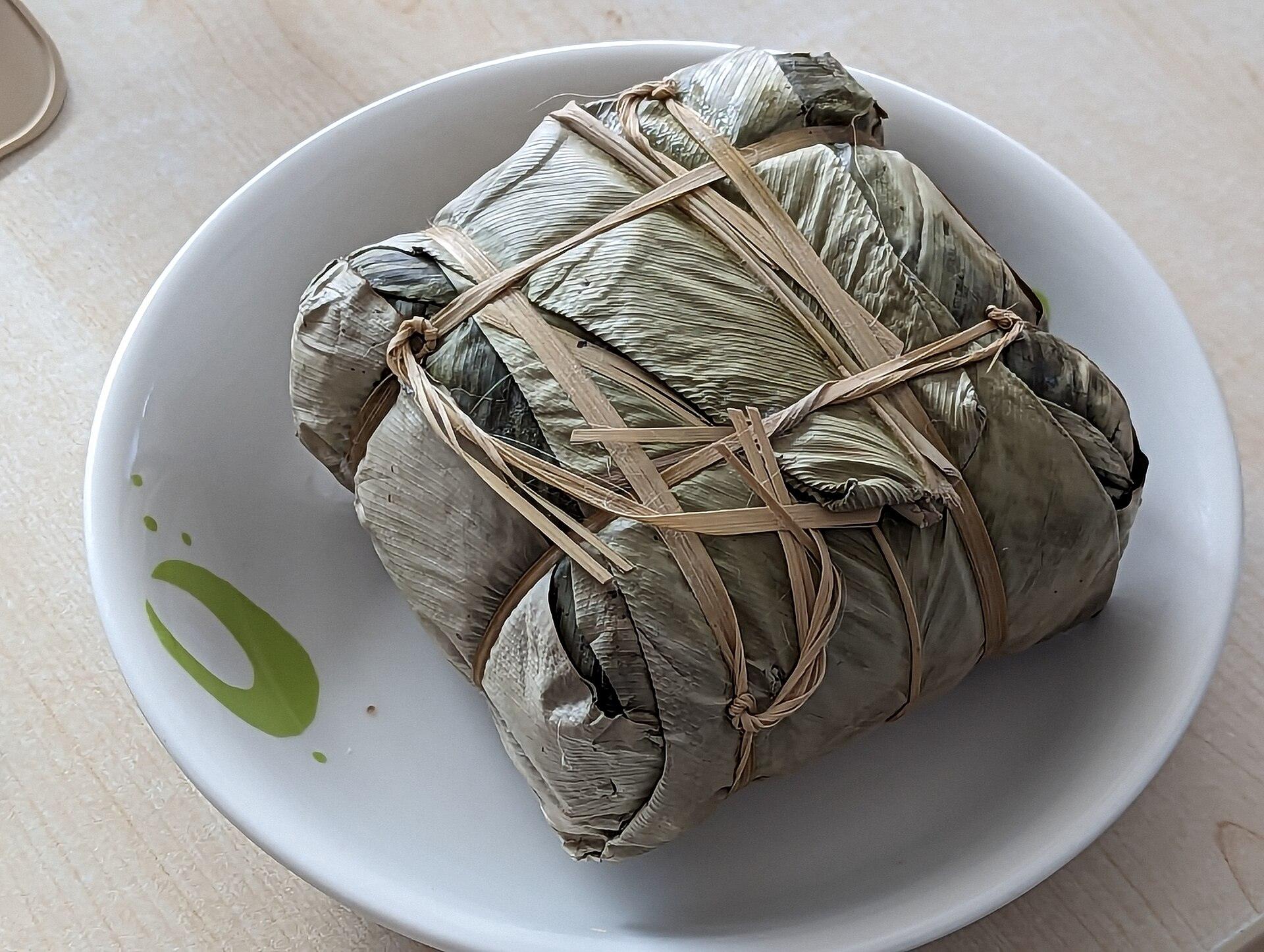 A finished banh chung square sticky rice cake served on a plate for Tet