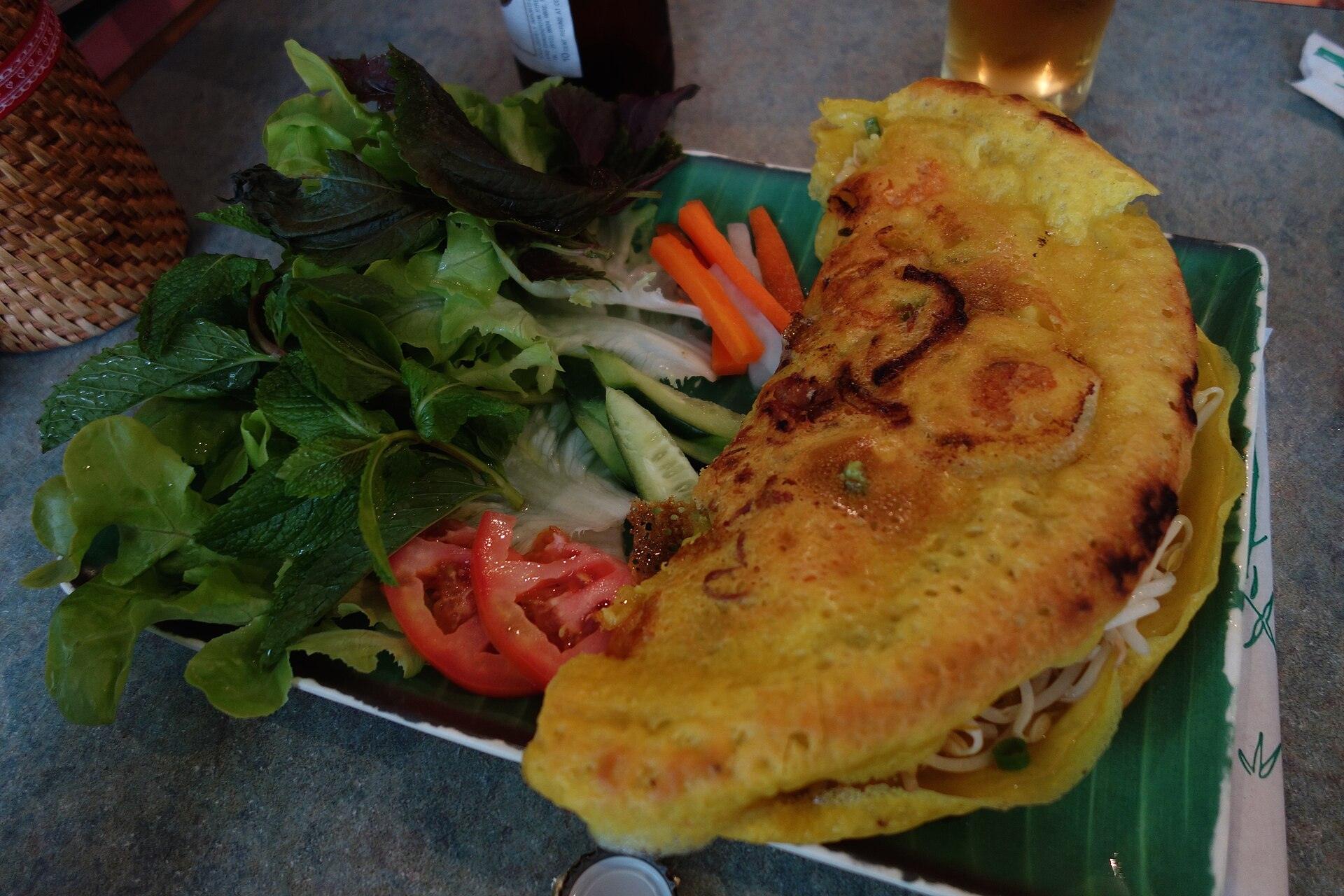 Banh xeo crispy Vietnamese sizzling pancake served with fresh herbs