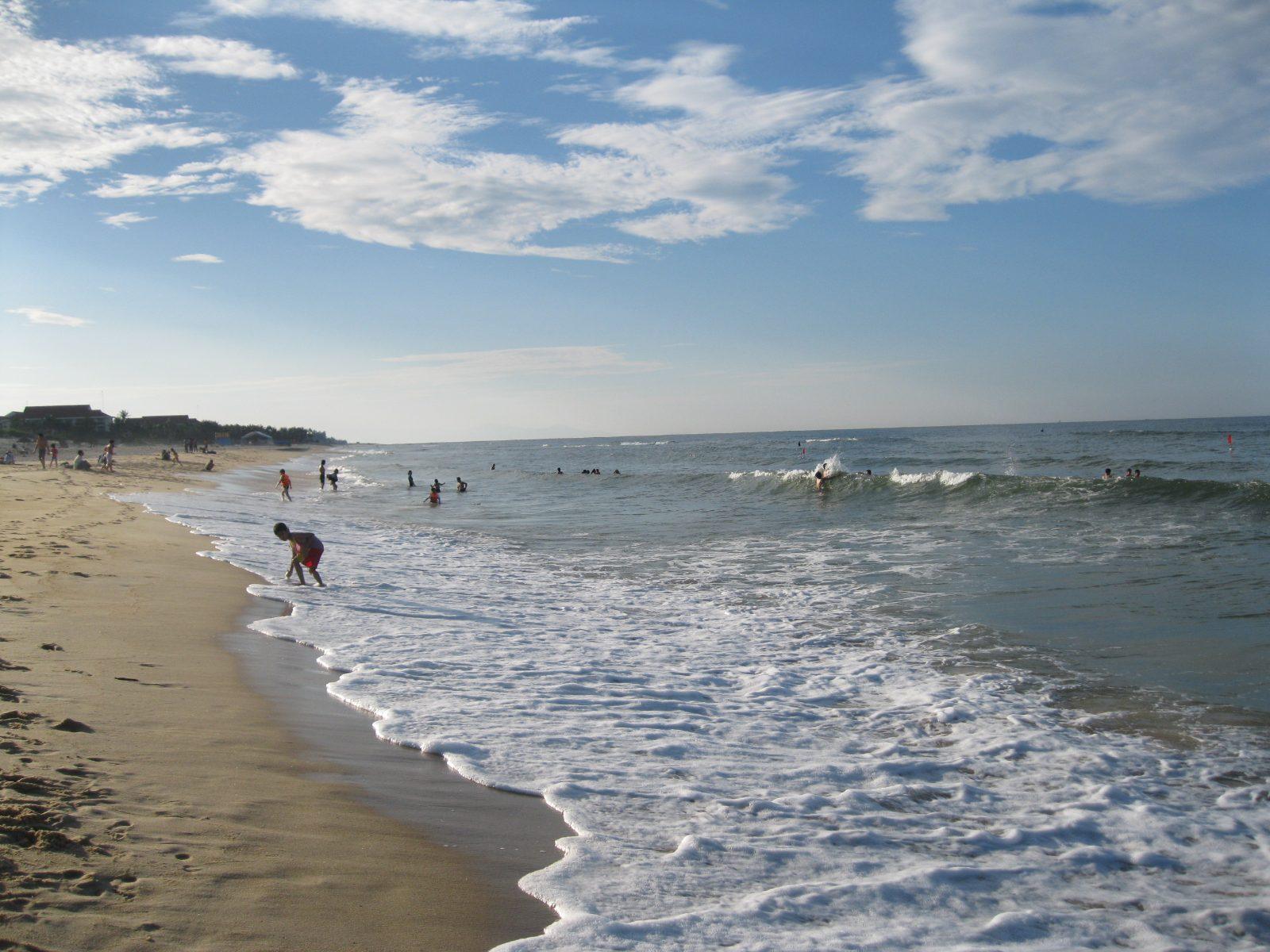 Bao Ninh Beach with swimmers and waves in Dong Hoi, Quang Binh, Vietnam