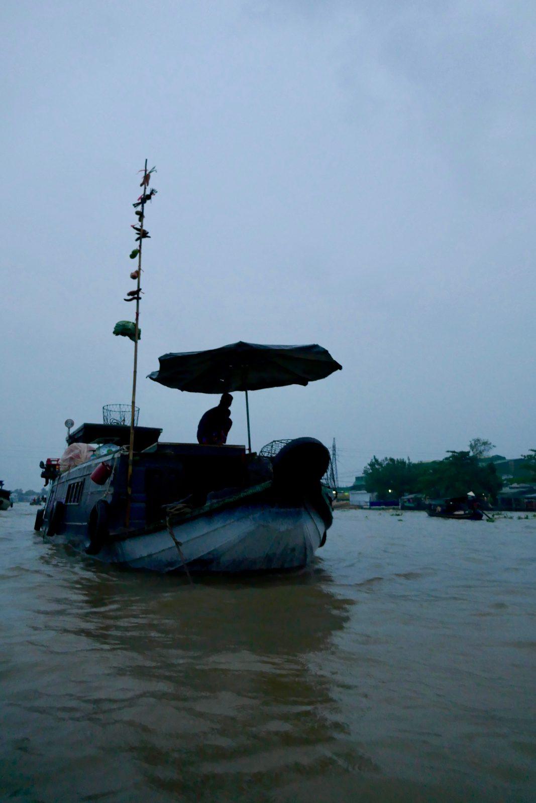 A boat with a bamboo pole displaying its goods at Cai Rang floating market, Can Tho