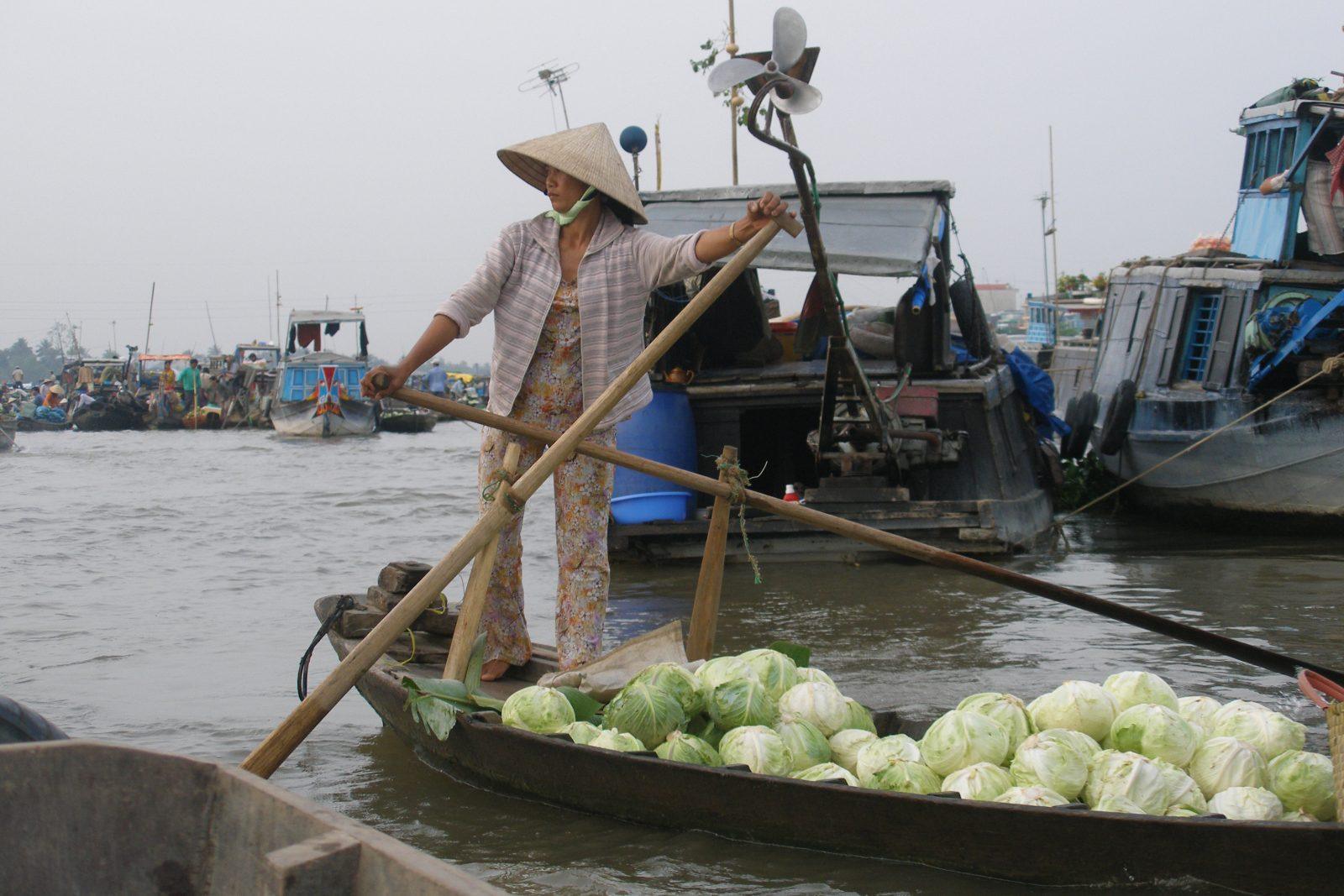 A vendor selling fruit and vegetables from a boat at Cai Rang floating market, Can Tho