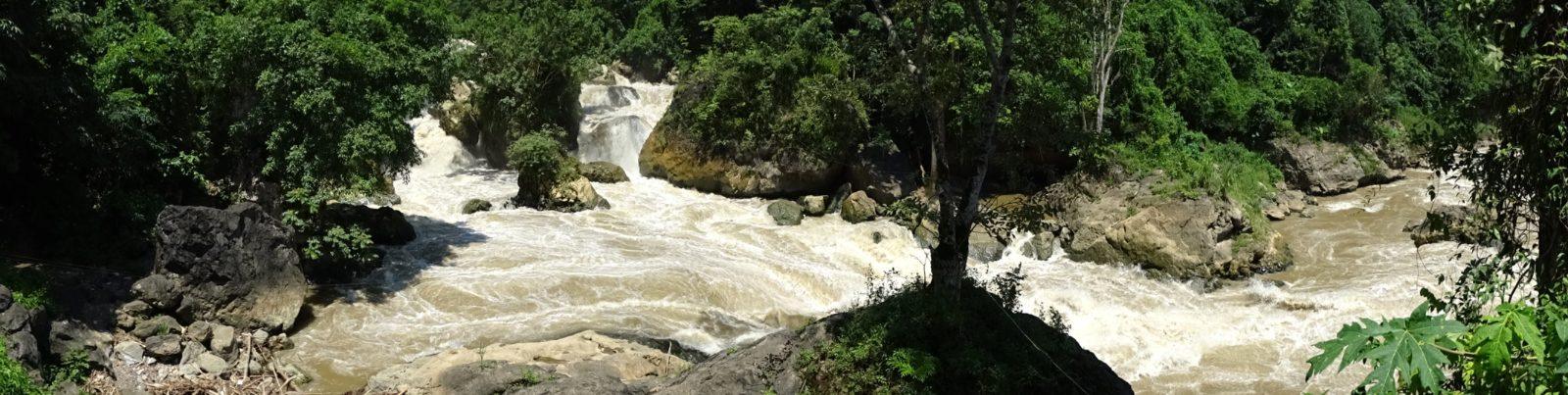 Wide panorama of Dau Dang Waterfall cutting through the forest near Ba Be Lake