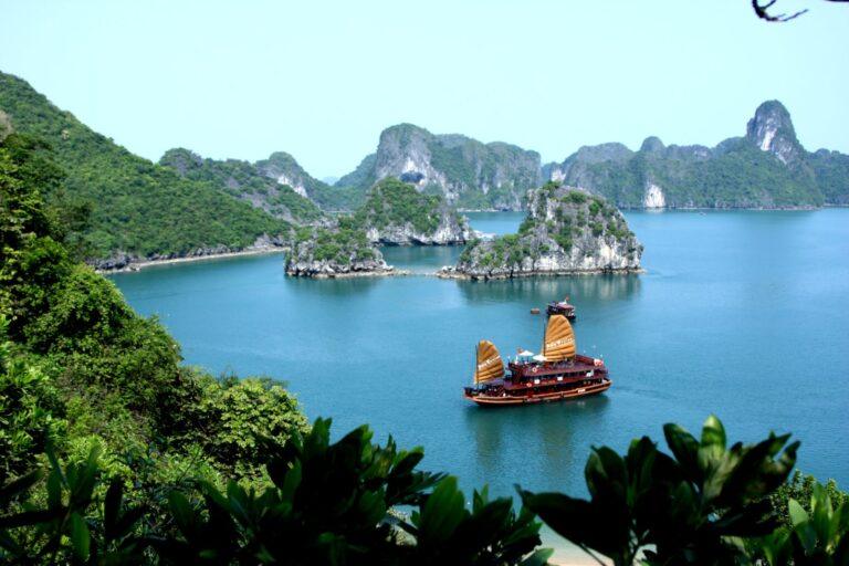 A traditional-style cruise junk boat sailing through Ha Long Bay