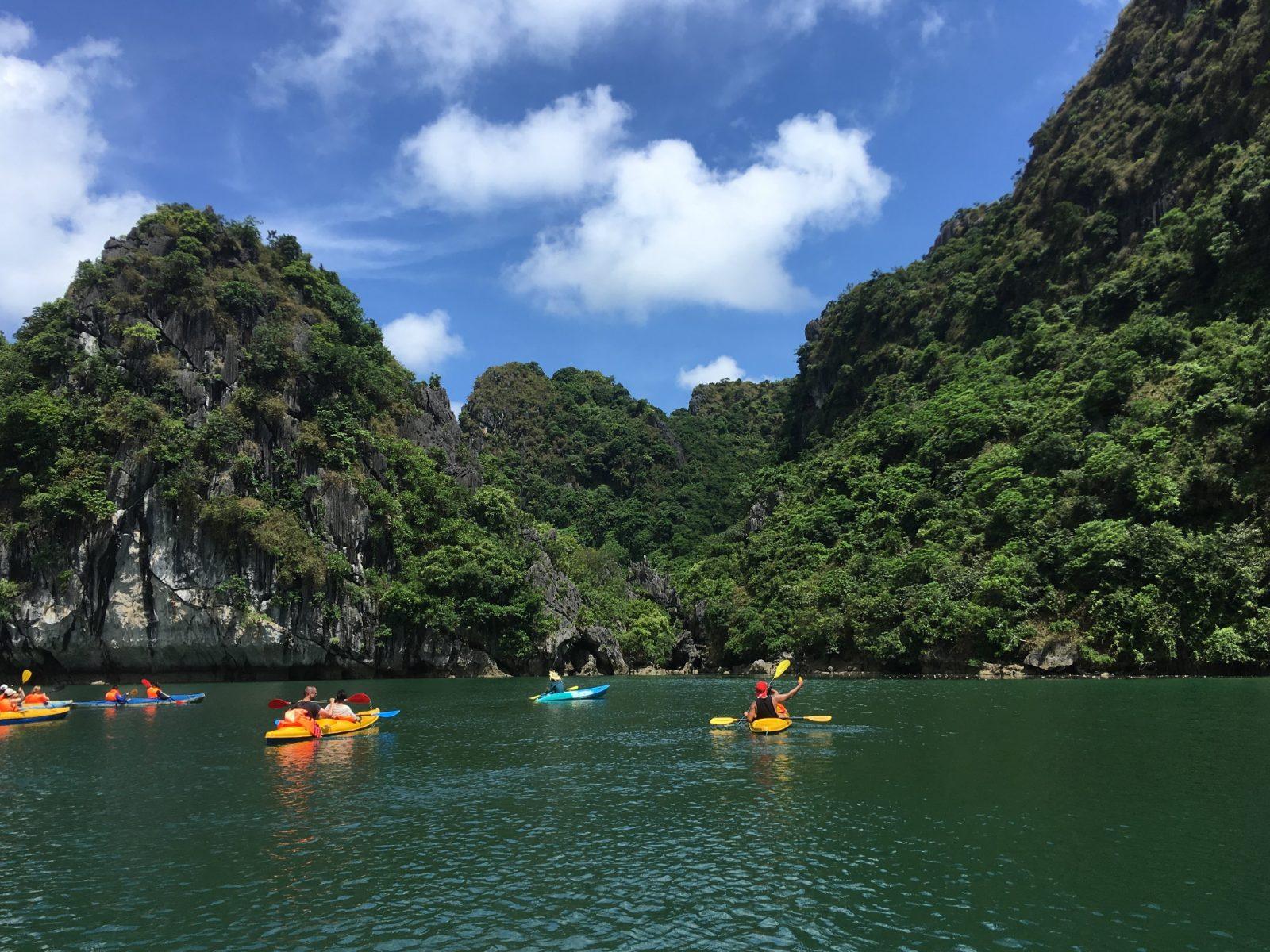 Tourists kayaking among the limestone karsts of Ha Long Bay