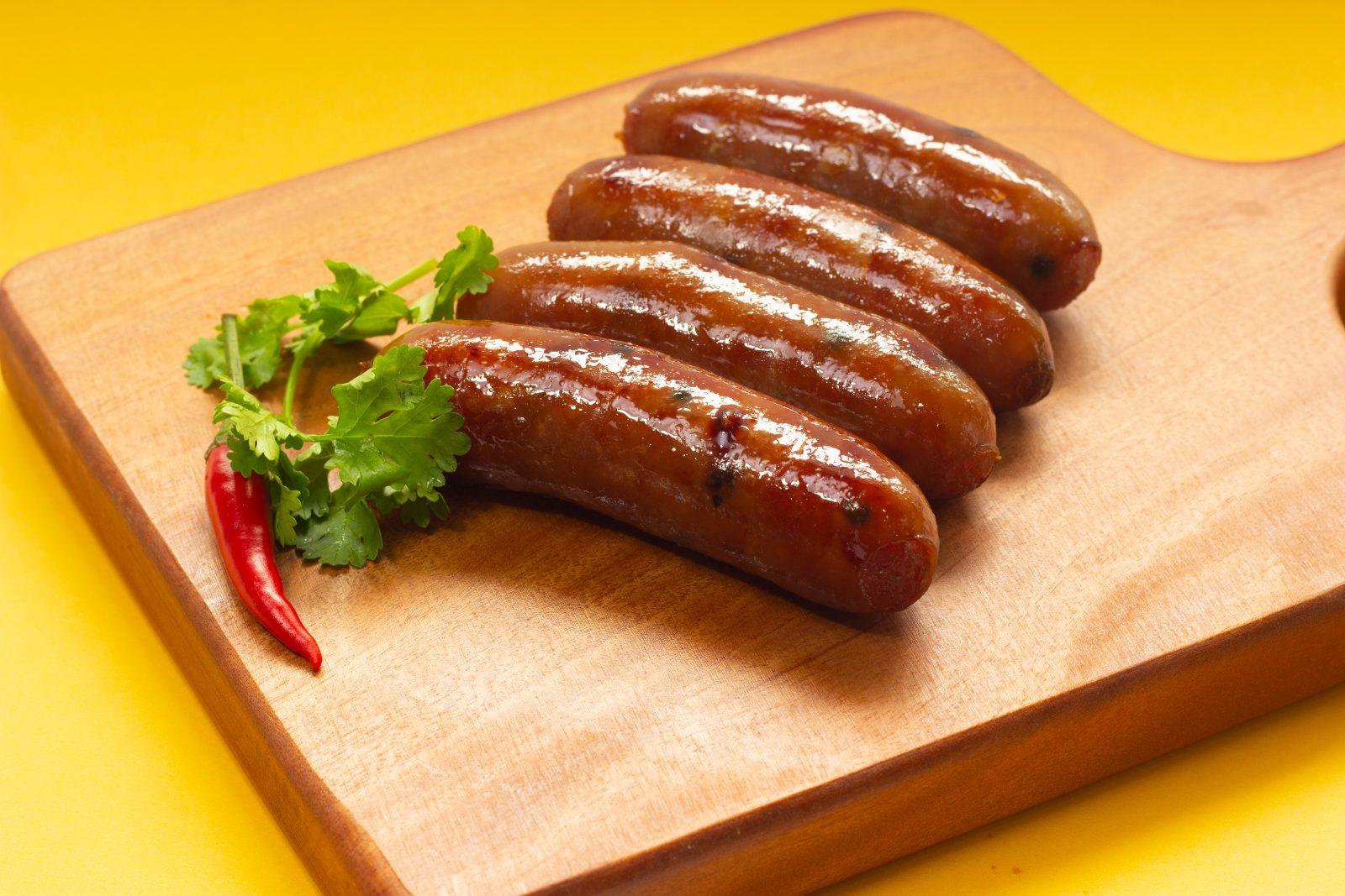Grilled Vietnamese sausage (lap xuong) served on a wooden board