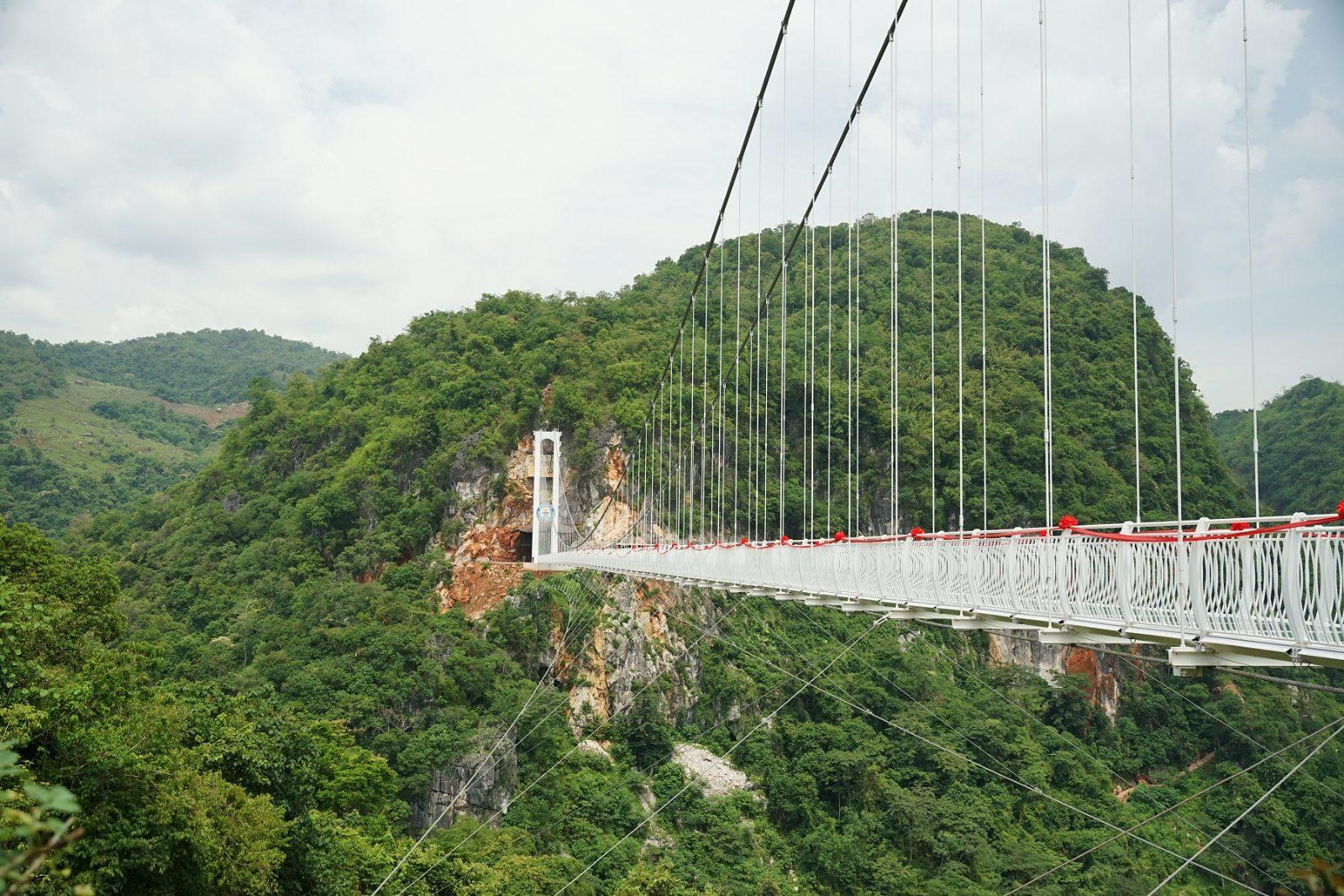 Bach Long glass-bottomed bridge spanning a forest valley in Moc Chau, Vietnam