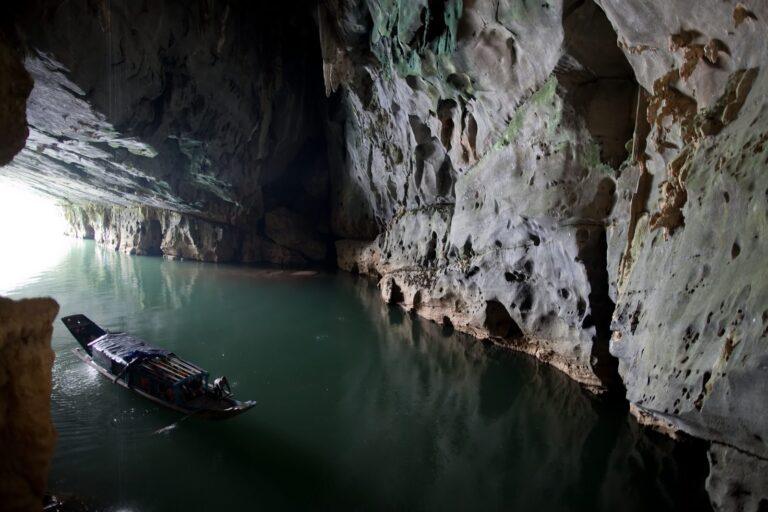 Small boat entering the river mouth of Phong Nha Cave