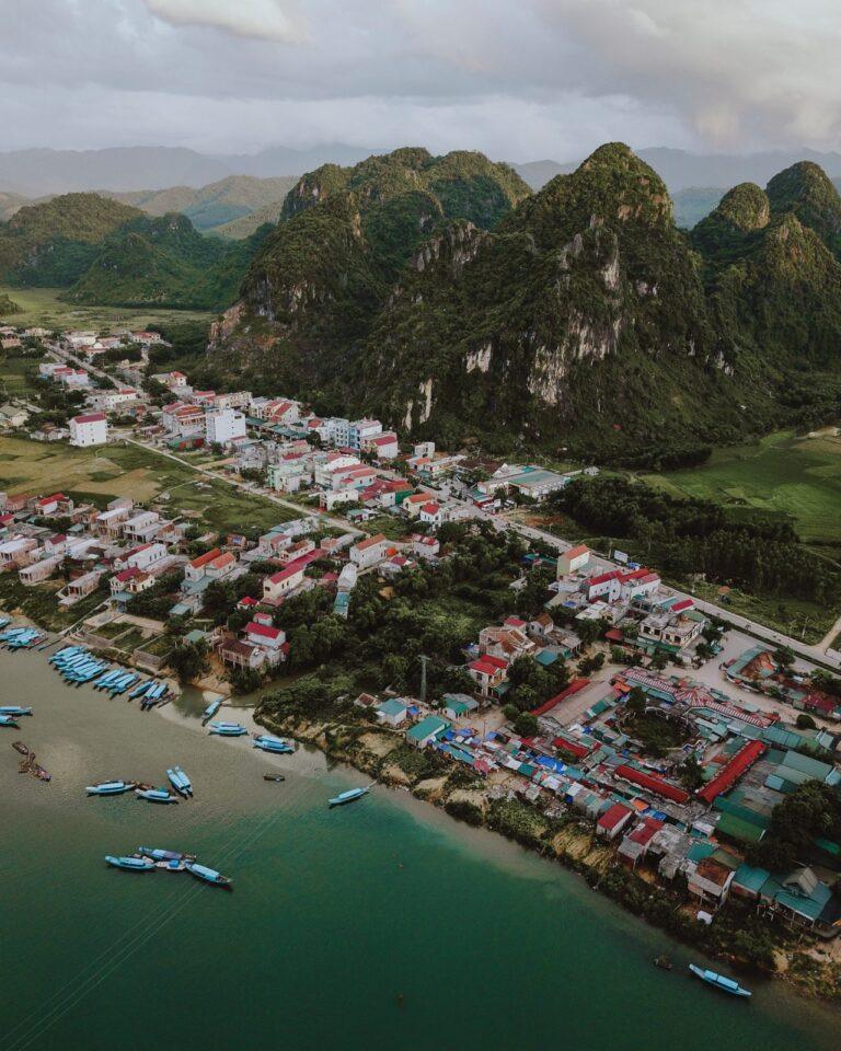 Aerial view of Phong Nha village beside the river with karst mountains behind it