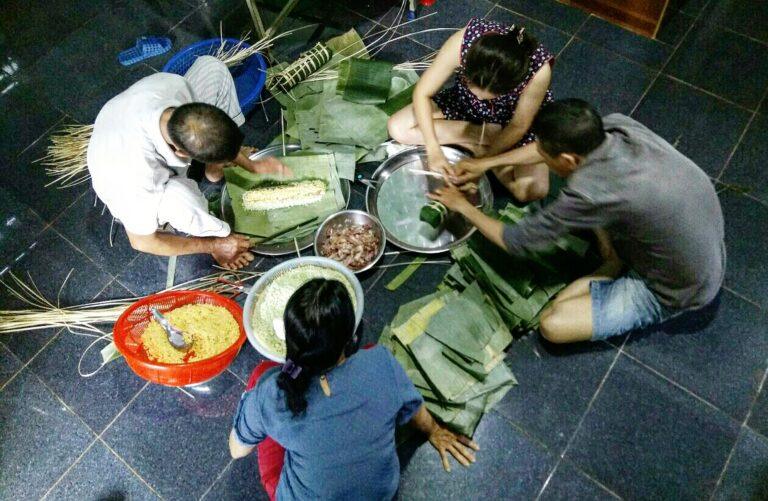 A Vietnamese family wrapping banh chung together to prepare for Tet