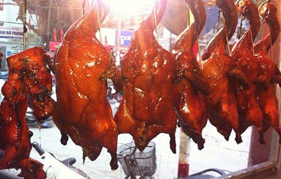 Whole roast ducks hanging in a shop window, a specialty of the Cao Bang and Lang Son region
