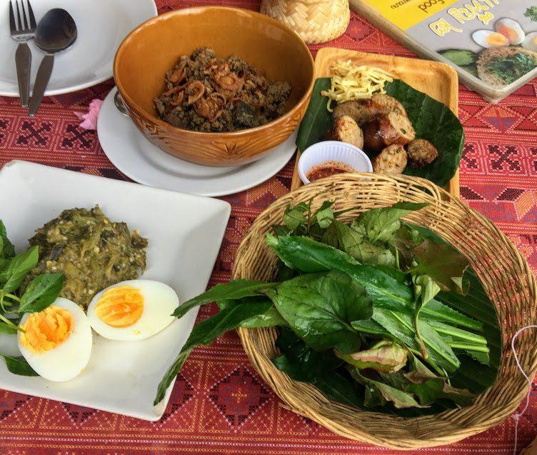 A northern Thai food platter with herbs, eggs, and relishes